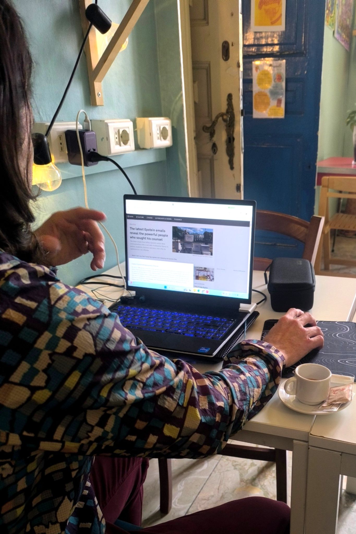 Cozy coworking corner in Catania with laptop, coffee and colorful décor at Ostello degli Elefanti.