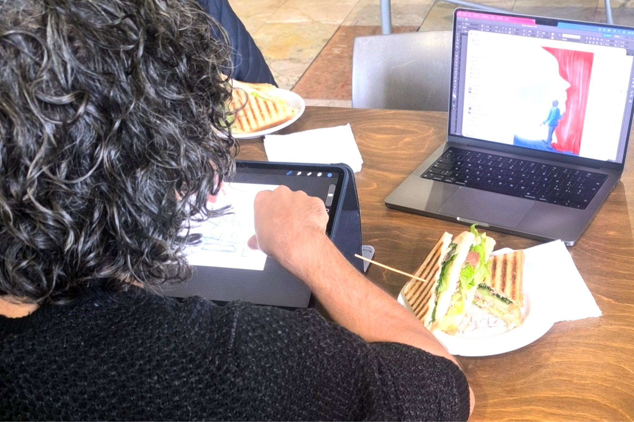 Digital artist Brus.pp, member of the Ostello degli Elefanti community, drawing on a tablet while working in the coworking area.